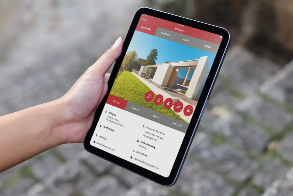 Hand holding a tablet displaying a fire safety inspection app for a property in Newport Beach, CA.