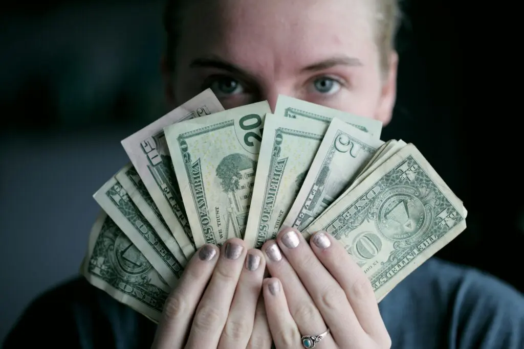 Woman holding money, symbolizing Commercial Fire Protection Fire Safety investments in Newport Beach, CA.